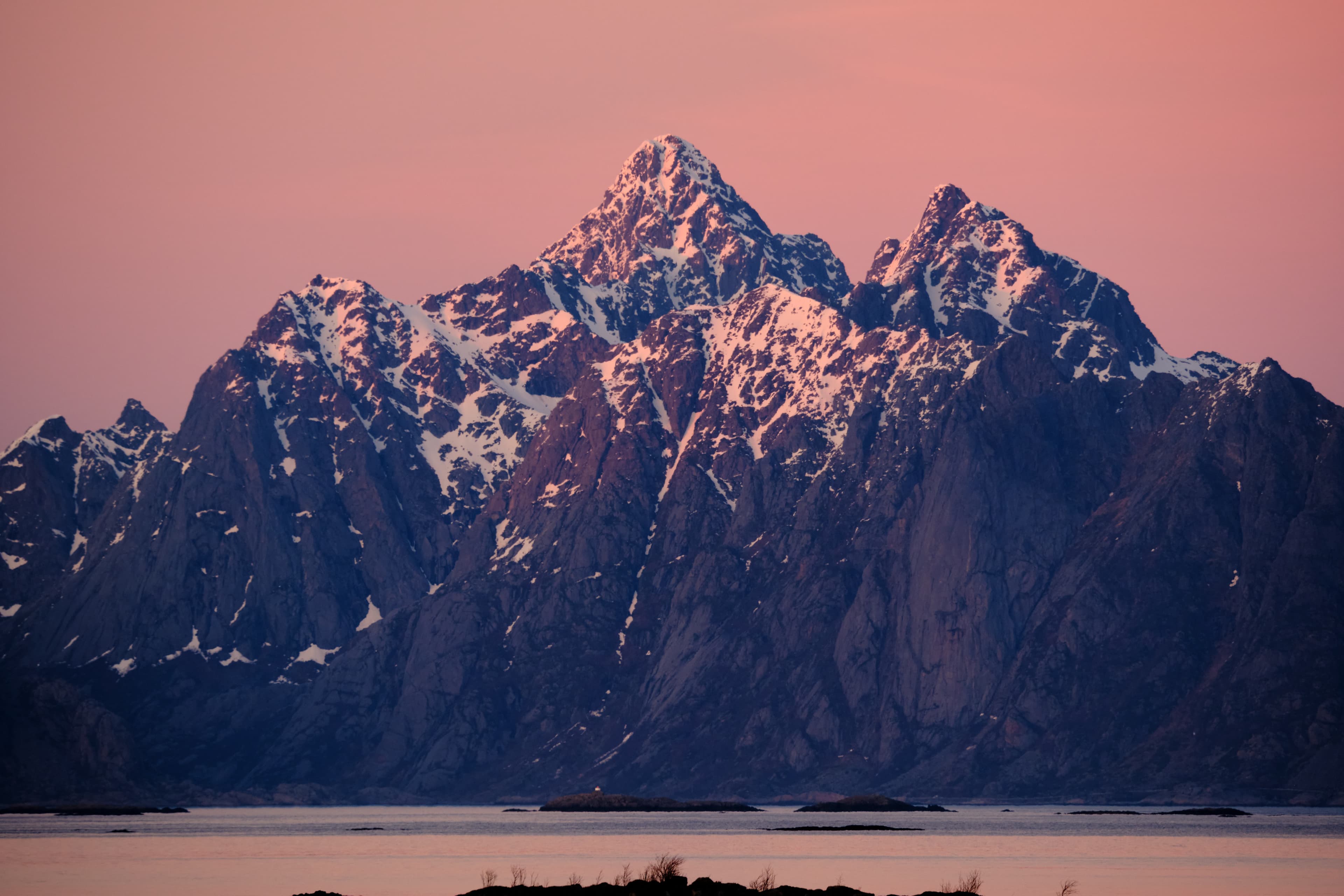 Snow-capped peaks in deep pink alpenglow