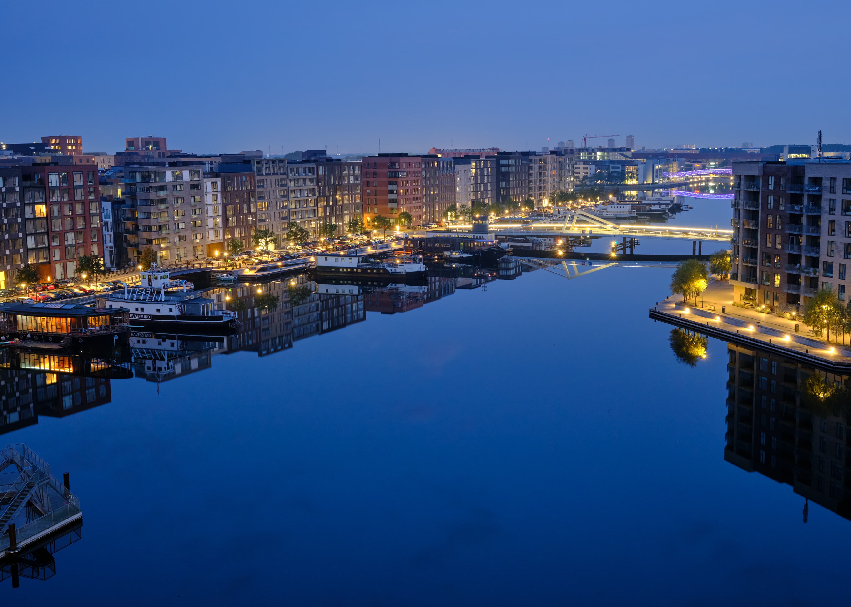 Copenhagen harbour canal at blue hour, houseboats and city lights reflected