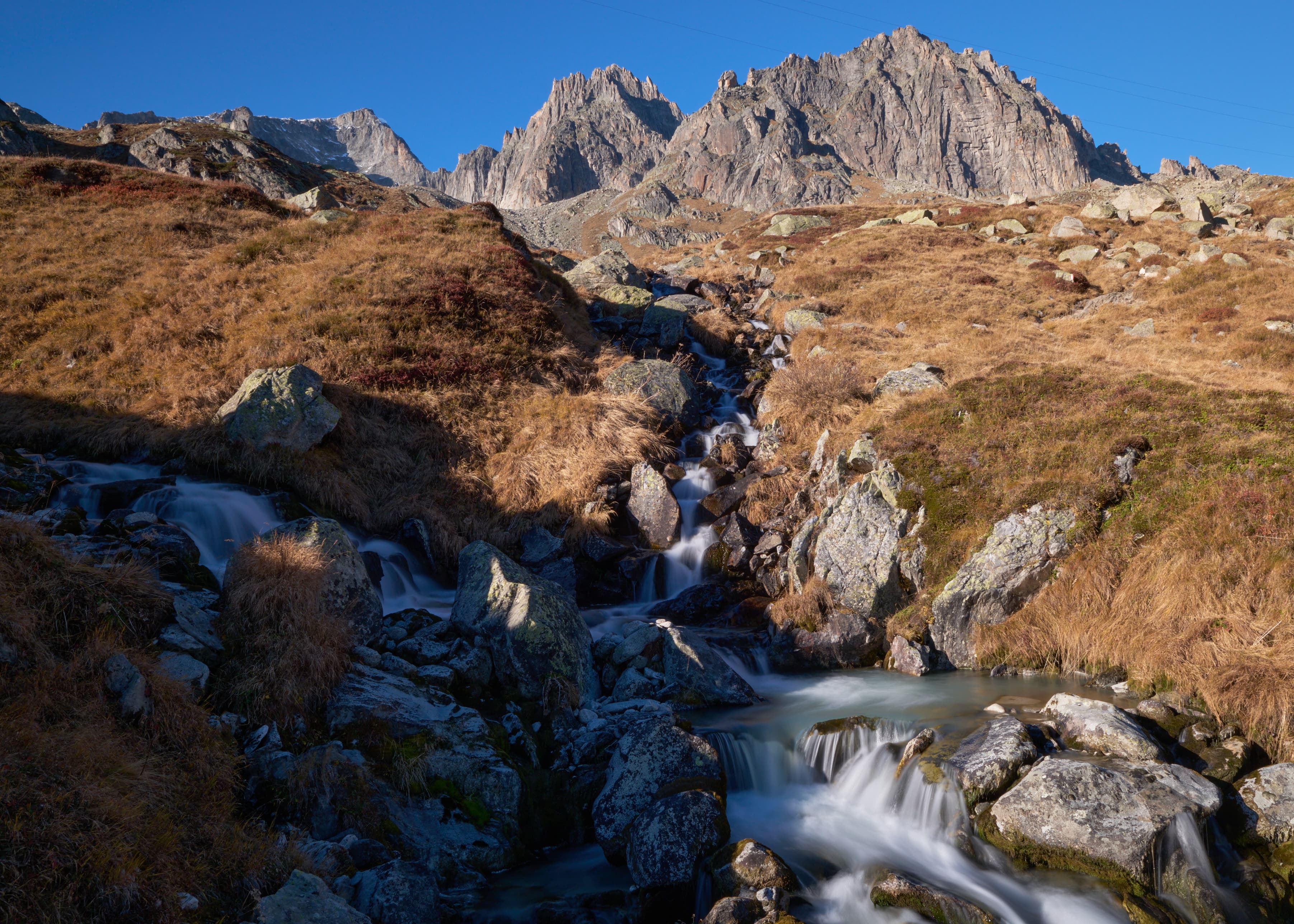 Alpine stream cascading over rocks toward Sustenpass peaks