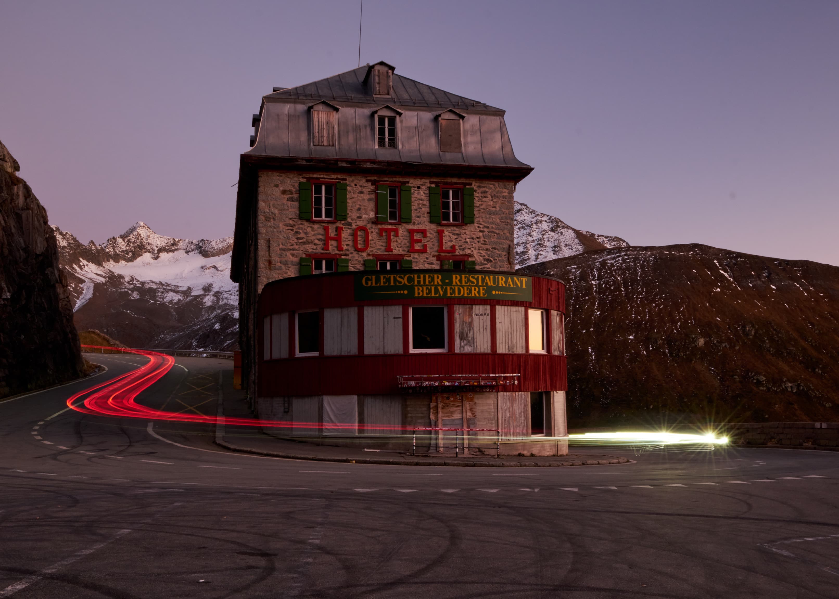 Abandoned Hotel Belvedere at night with car light trails