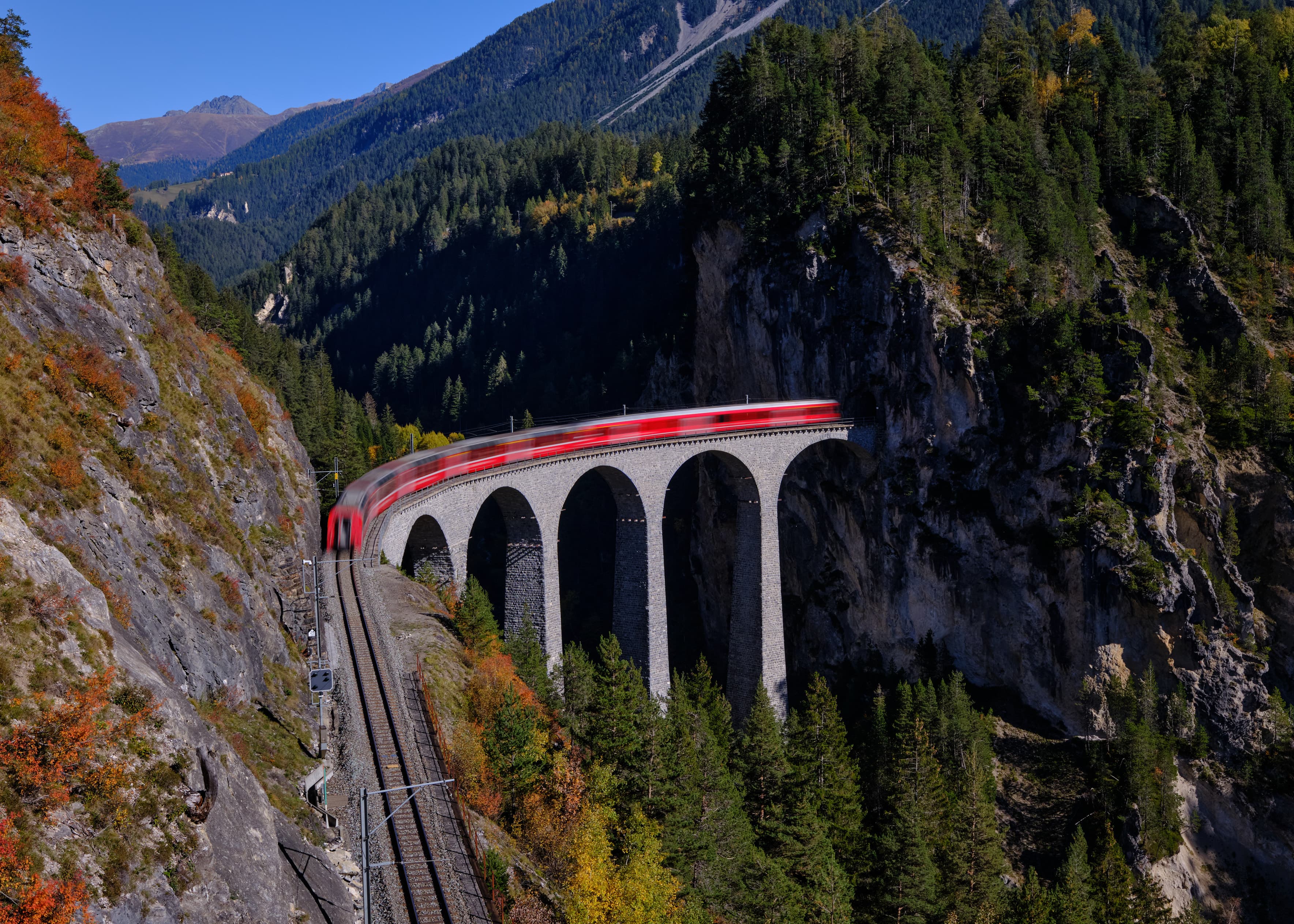 Red Rhaetian Railway train crossing Landwasser Viaduct