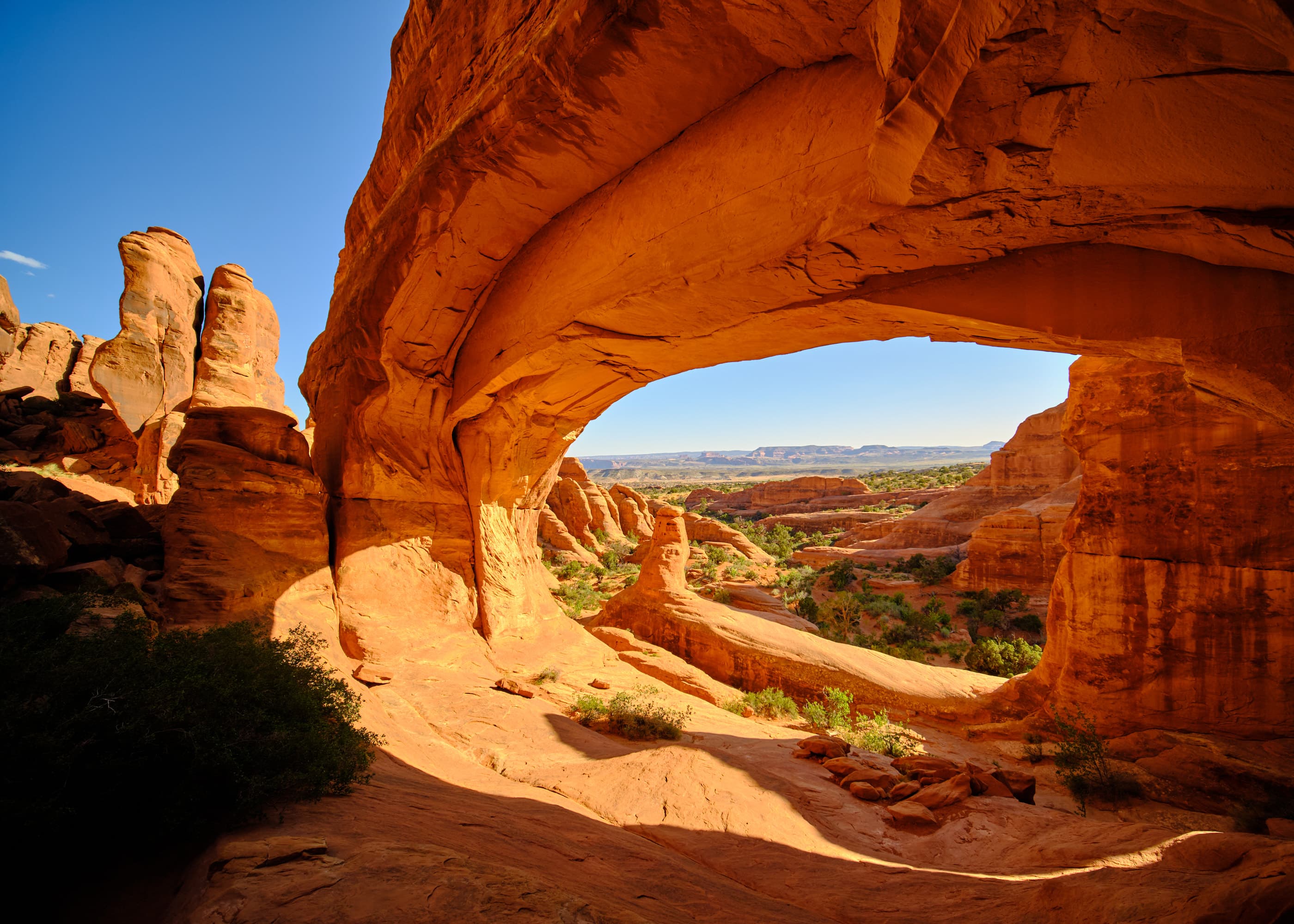 Stone arch interior framing canyon valley, Arches NP