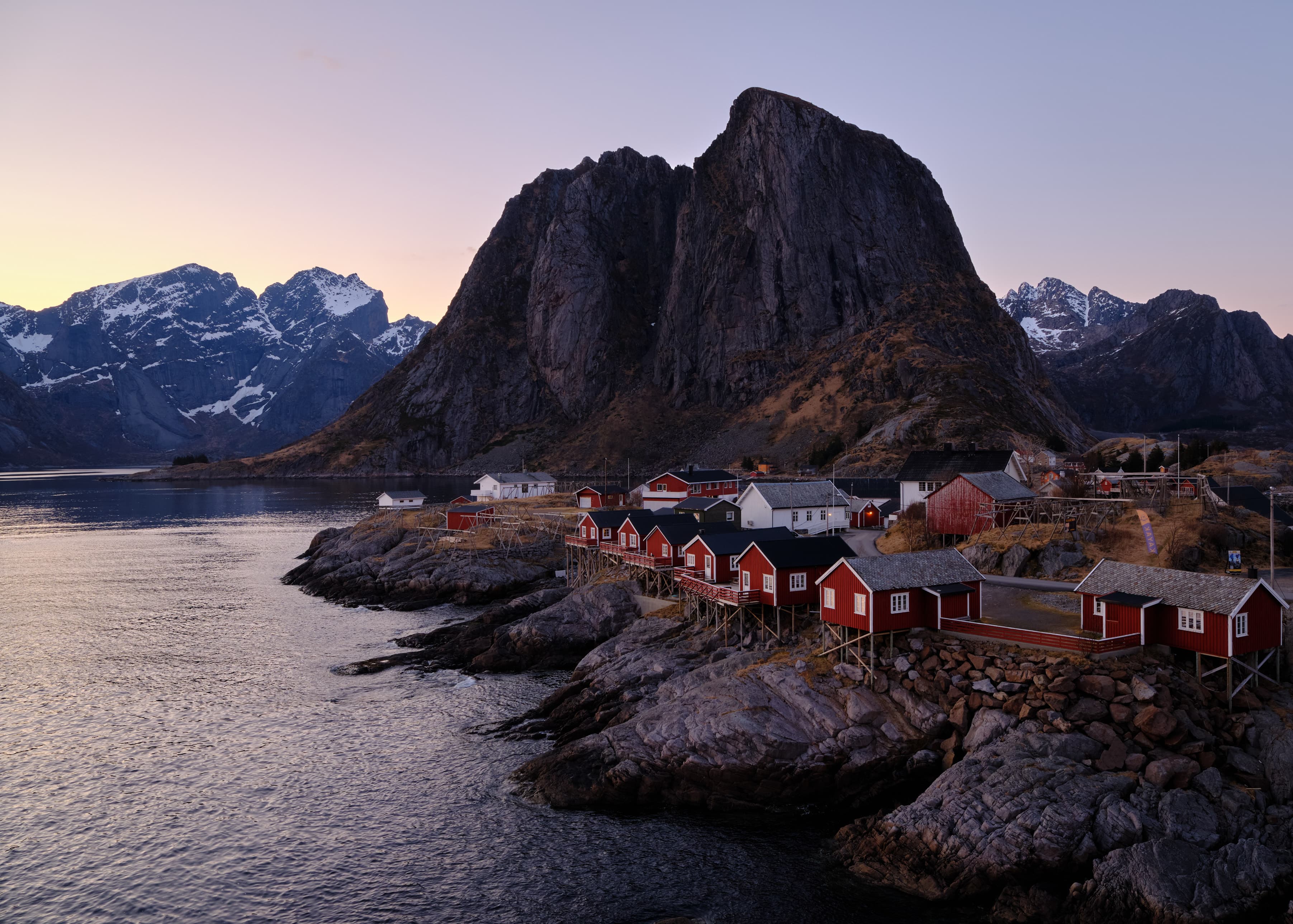 Hamnøy village at dusk, towering black rock monolith
