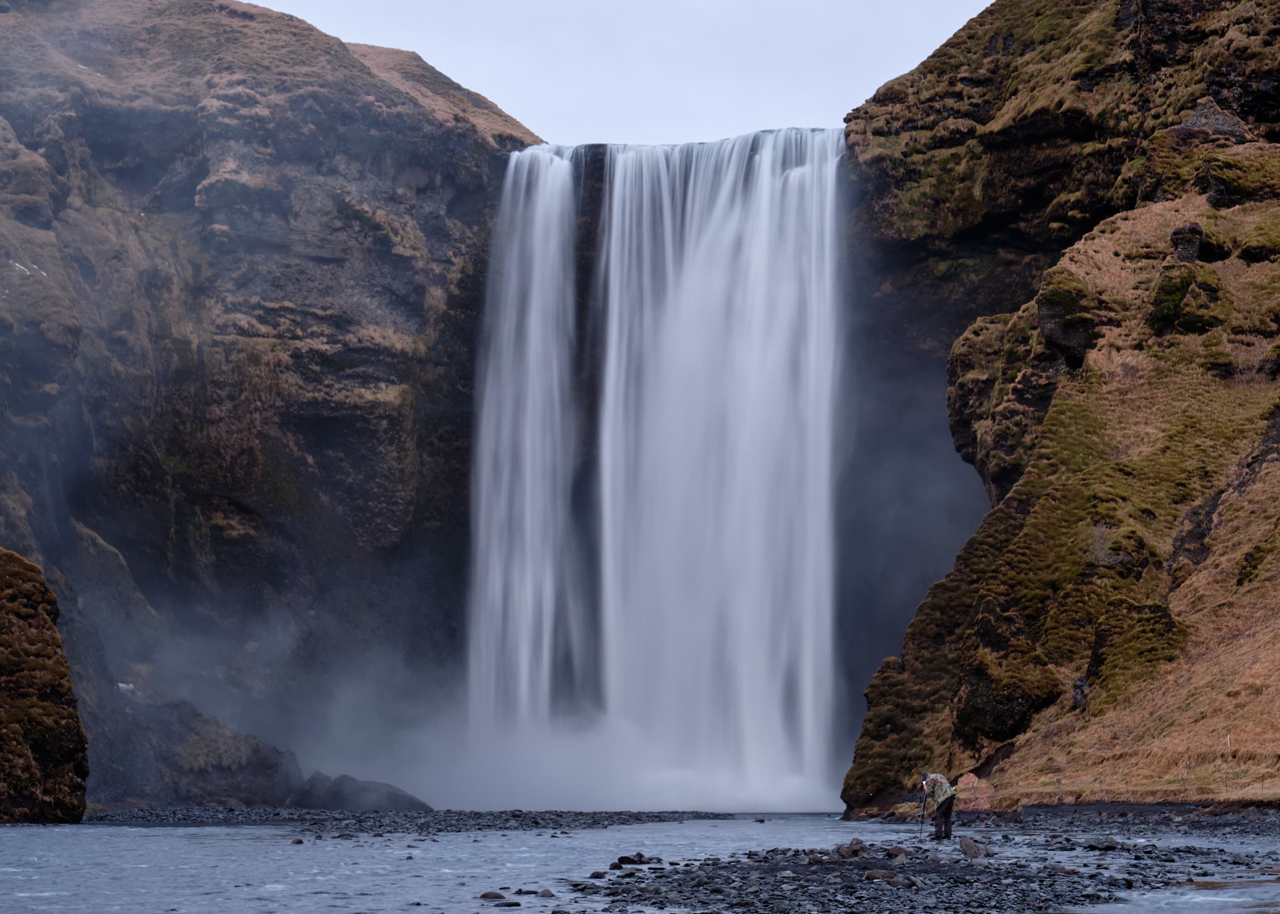 Skógafoss waterfall with lone figure for scale