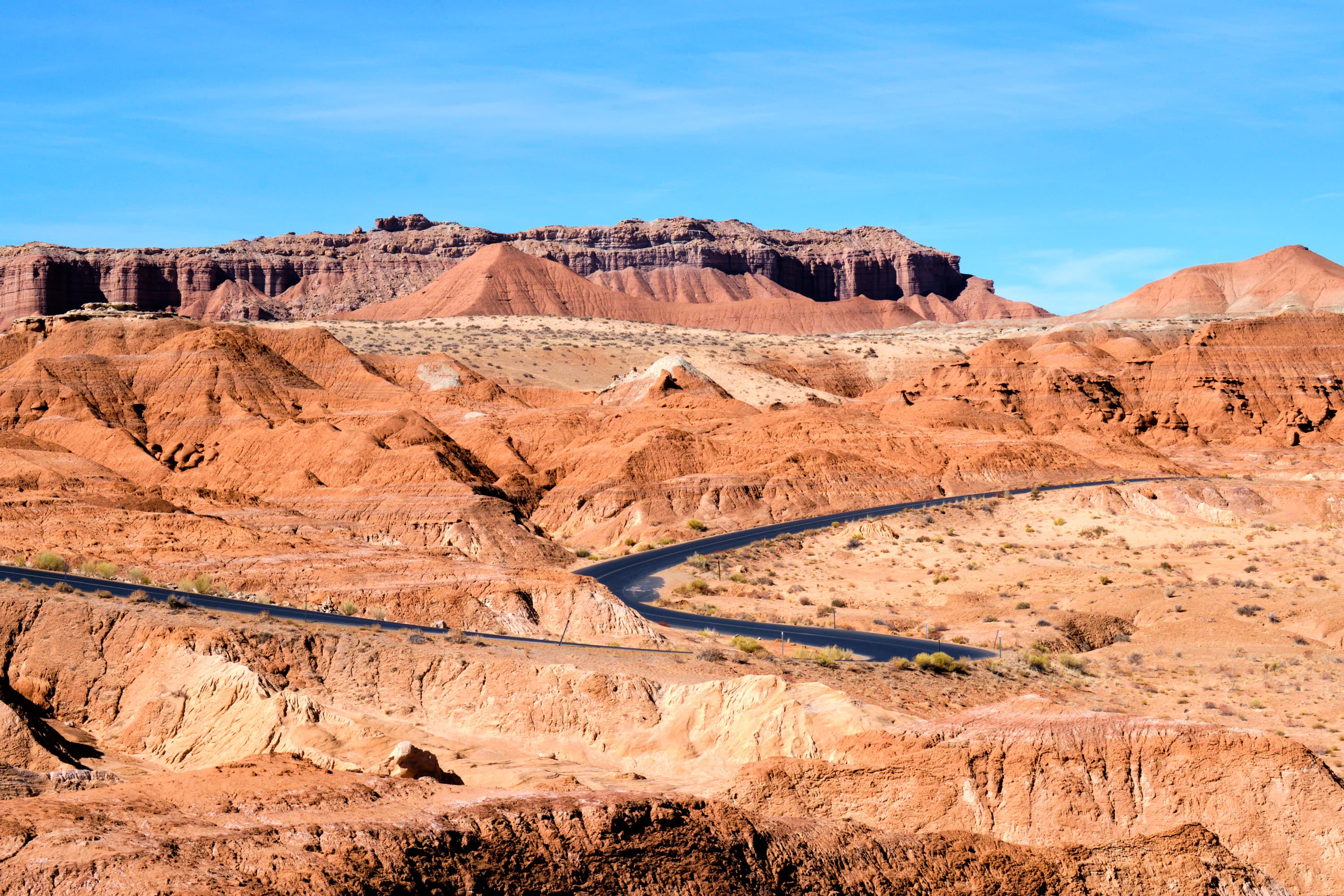 Winding road threading Capitol Reef badlands, red canyon walls